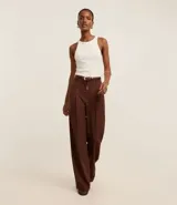 Blusa sin mangas de corte regular, confeccionada en tejido rib de algodón con cuello redondo. Presenta un diseño minimalista y anatómico, ideal para un look clásico.