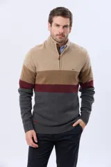 Buzo tejido de punto con diseño de bloques de color horizontales en tonos beige, marrón, bordó y gris. Presenta cuello alto con cierre frontal parcial y detalle en gamuza en el tirador.