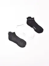 Pack de tres pares de soquetes deportivos, uno negro, uno blanco y uno gris oscuro, con banda elástica superior con líneas grises.