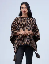 Poncho tejido con diseño tribal en blanco y negro, terminación con borlas.