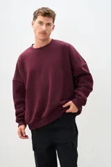 Buzo de cuello redondo color bordó, de corte amplio y mangas largas.