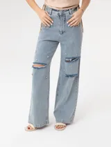 Pantalón de jean celeste de corte ancho, con roturas en las rodillas y apliques de strass.