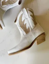 Bota corta estilo western de cuero color marrón, con taco cuadrado de 5 cm y diseño clásico. Presenta un acabado desgastado en la puntera y el talón.