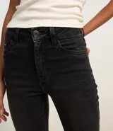 Pantalón de jean negro, corte boot cut, tiro alto, con bolsillos delanteros y traseros.