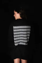 Buzo negro oversize de frisa con cuello redondo, hombros caídos y terminaciones de rib. Presenta logo bordado a tono en el frente y estampa serigrafiada a contratono en la espalda.