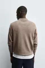 Polo de punto de corte regular fit, confeccionado en una mezcla de lana y cashmere. Presenta cuello solapa con cierre frontal de dos botones, manga larga y terminaciones en rib.