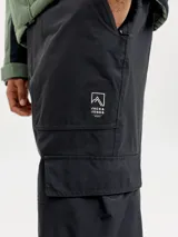 Pantalón técnico de ski Jack & Jones, impermeable y cortaviento, con corte holgado. Presenta bolsillos cargo laterales con solapa y cierre de velcro, bolsillos frontales y logo de la marca estampado en el muslo. Incluye polainas internas y refuerzos en los ruedos para protección contra la nieve.