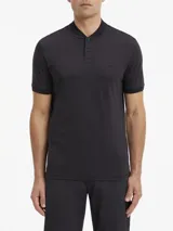 Chomba de algodón negra, manga corta, con cuello mao y tapeta de dos botones. Presenta un pequeño parche con micro logo en el pecho.