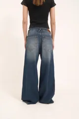 Pantalón de jean con corte baggy de tiro medio, diseño de cinco bolsillos y acabado desgastado en tono gris oscuro.