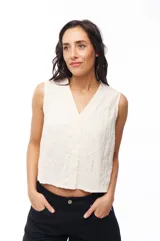 Blusa color crema con botones, sin mangas y cuello en V.
