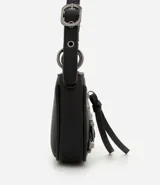 Cartera tipo baguette de PU color beige claro, con acabado liso y detalles de apliques metálicos tipo tachas y argollas en color gunmetal. Presenta un bolsillo frontal con cierre y un tirador de cuero sintético colgante. Incluye asa corta ajustable con hebilla.