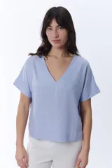 Blusa de manga corta con escote en V profundo, corte holgado y confeccionada en tejido de lino.