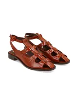Sandalias de cuero color suela con textura efecto cocodrilo, diseño de tiras cruzadas tipo gladiadora, taco bajo y tira ajustable en el tobillo con hebilla redonda.