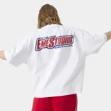 Remera oversized de algodón blanca, de manga corta y cuello redondo, con estampado gráfico multicolor en la espalda.