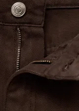 Jeans tiro medio de corte barrel y diseño balloon color marrón, con cierre de botón y cremallera, trabillas y cinco bolsillos.