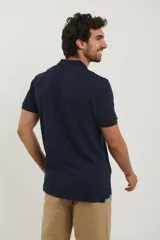 Polo de piqué color rojo, manga corta, con cuello y tapeta de botones al tono.