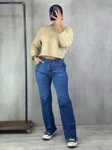 Pantalón de jean azul de corte wide leg, con cintura alta y terminación desflecada en el ruedo.