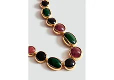 Gargantilla de eslabones dorados decorados con piedras ovaladas de resina en tonos verde, rojo y negro.