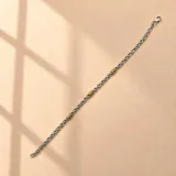Pulsera de cadena de eslabones entrelazados en plata 925, con tres apliques cilíndricos texturizados en oro. Cierre de mosquetón.