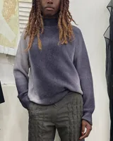 Buzo de tejido de punto en lana merino, con diseño oversize, manga ranglan y cuello levemente elevado. Presenta una textura de punto grueso y se destaca por sus colores vibrantes.