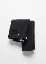 Jeans skinny de tiro alto en color negro, con diseño de cinco bolsillos, trabillas para cinturón y cierre frontal con cremallera y botón.