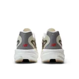 Championes de running New Balance SuperComp Rebel V1, color blanco marfil con detalles en gris y negro, logo "N" en el lateral y entresuela amortiguada con tecnología Energy Arc e Infinion Foam.