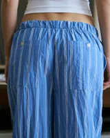 Pantalón de poplin de algodón a rayas verticales celestes y blancas, con cintura elástica y bolsillos traseros.