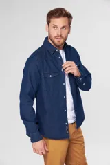 Camisa de jean celeste de manga larga, con cuello clásico, cierre frontal con botones a presión, dos bolsillos con solapa abotonada en el pecho, corte en hombros y detalle en la espalda.