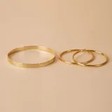 Aros tipo argolla de oro 18k con diseño torneado y acabado brillante.