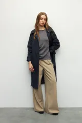 Top sin mangas color beige, de cuello redondo y corte ajustado. Presenta frunces en los laterales.