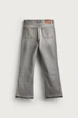 Jeans flare fit de denim negro, tiro medio, ajustados arriba y con botamanga acampanada. Cuentan con cinco bolsillos, lavado efecto gastado y bajo con acabado irregular. Cierre frontal con cremallera y botón.