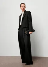 Blazer de corte recto y diseño crop, con cuello de solapa con muesca, cierre frontal de gancho y mangas largas con puños abotonados. Cuenta con bolsillos de ribete frontales y en el pecho, y forro interior.