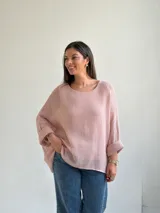 Sweater de punto en color rosado, con diseño holgado, cuello redondo y mangas murciélago anchas con vuelta.