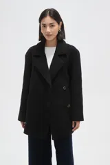 Chaqueta de corte holgado en color negro, con cuello solapa, cierre frontal con botones y bolsillos laterales.