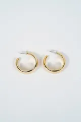 Aros tipo argolla de diseño grueso y acabado brillante en tono dorado.