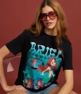 Remera de algodón negro, modelo t-shirt con cuello redondo y manga corta. Cuenta con una estampa frontal colorida de la princesa Ariel de Disney y la inscripción 'Princess World Tour'.