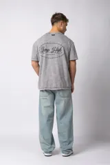 Remera de algodón con efecto lavado ácido en color gris, de corte holgado y manga corta. Presenta estampados gráficos minimalistas en el pecho y cuello redondo acanalado.