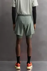 Short de entrenamiento deportivo con diseño 2 en 1, que incluye una capa exterior de tejido técnico ligero y una malla interior ajustada. Cuenta con cintura elástica con cordón de ajuste, bolsillos laterales con cierre y aberturas en el bajo.