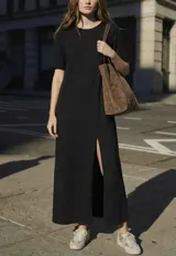 Vestido largo negro de manga corta y cuello redondo, con abertura lateral en la falda.