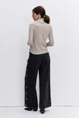 Jersey de punto fino en color negro, con cuello alto y mangas largas ajustadas.