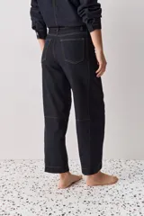 Jean de corte barrel, tiro alto, con silueta amplia que se estrecha hacia el tobillo. Confeccionado en denim azul oscuro con costuras a contratono.