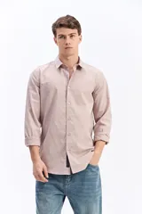 Camisa de manga larga color rosa pálido, con cuello tradicional y cierre frontal de botones. Confeccionada en tejido liviano 100% algodón con textura sutil en relieve.