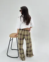 Pantalon de corte recto y holgado con estampado de cuadros en tonos verdes, marrones y blancos. Presenta cintura elástica con cordón de ajuste.