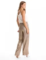Pantalón wide leg de tiro alto con diseño plisado vertical y acabado metalizado en tono dorado. Presenta una cintura elástica fruncida con lazo de ajuste frontal y bolsillos laterales ocultos.