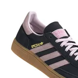 Zapatillas Adidas Handball Spezial de gamuza color negro con detalles en rosa, incluyendo las tres tiras laterales, el talón y los cordones. La suela es de goma color caramelo.
