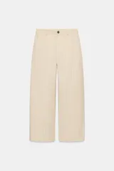 Pantalón barrel de tiro medio confeccionado en hilatura con lino, color beige con diseño a rayas sutiles. Cuenta con cintura con trabillas, bolsillos laterales ocultos en costura, pierna ancha y cierre frontal con cremallera y botón.
