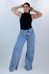 Jean wide leg baggy color azul, de tiro medio-alto, con diseño de costuras diagonales y bolsillos cargo laterales.