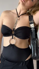 Body negro de lycra con escote strapless y abertura cut-out en la cintura.