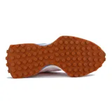 Championes New Balance 327, color rosa claro con detalles en gamuza rosa pálido y logo "N" lateral en azul. Cuentan con cordones blancos, lengüeta azul y suela de goma color caramelo.