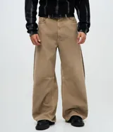 Pantalón masculino de corte barrel, confeccionado en sarga de algodón color beige. Presenta un diseño de piernas anchas con volumen en la cadera y leve entalle hacia el bajo, cintura con pasantes, cierre frontal con botón y bolsillos funcionales.